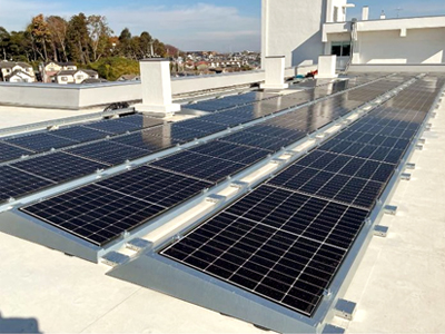 公立中学校の屋上（陸屋根）に設置されたアンカーレス太陽光架台「フォービスソーラーベース」　